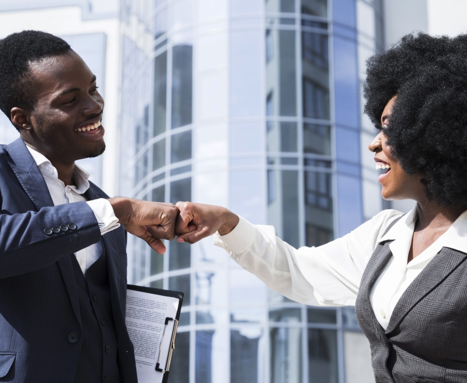 businessman-businesswoman-bumping-their-fist-front-corporate-building