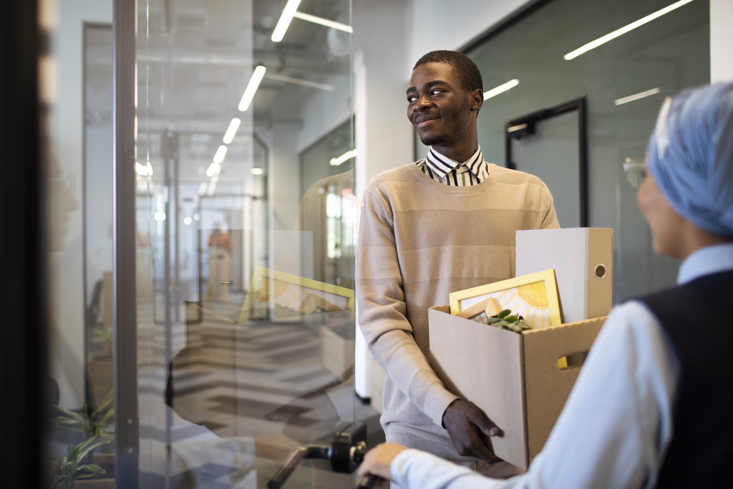 man-holding-box-belongings-settling-his-new-office-job